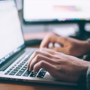 student hands typing on laptop